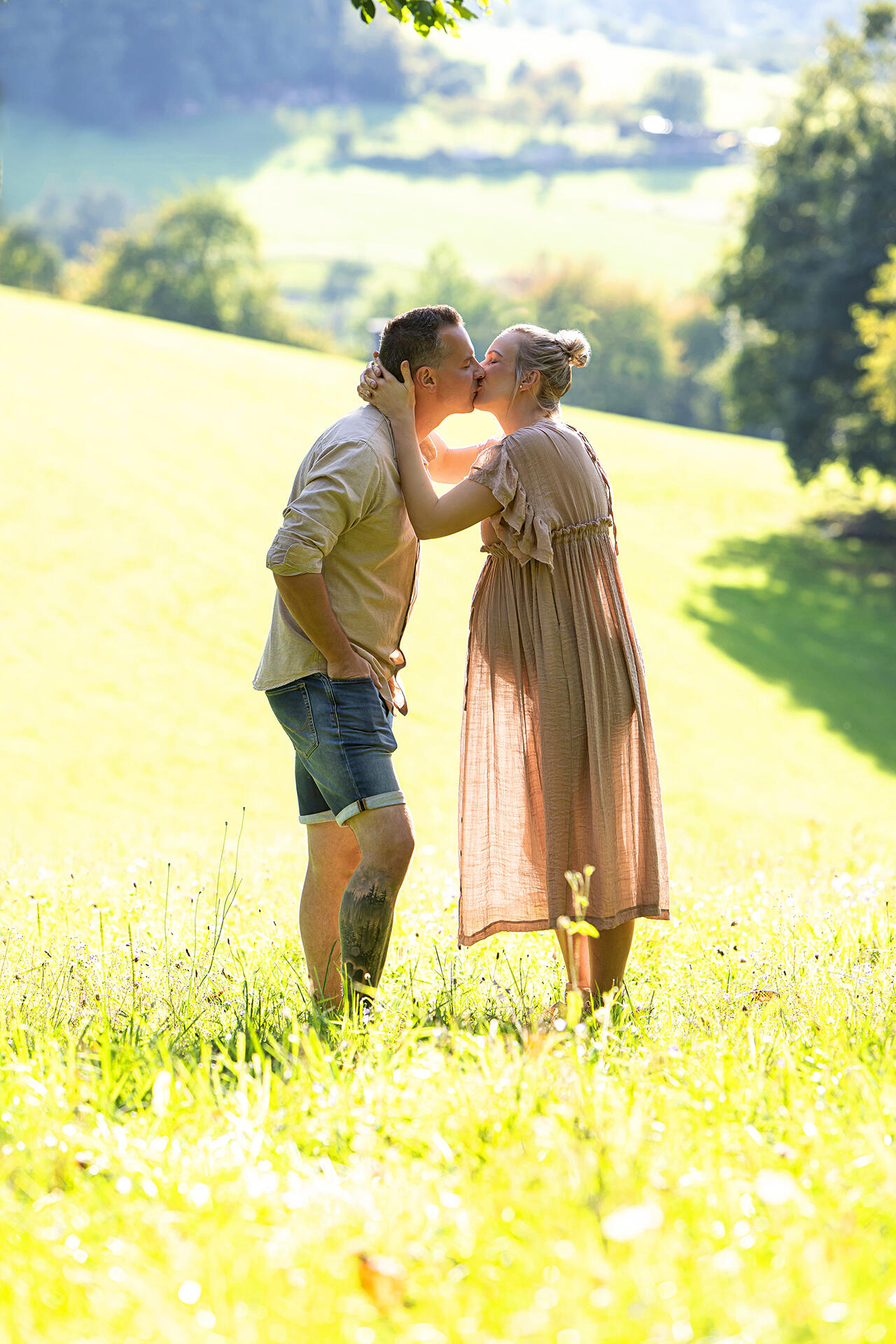 Küssendes Paar auf einer Wiese vor Landschaftspanorama