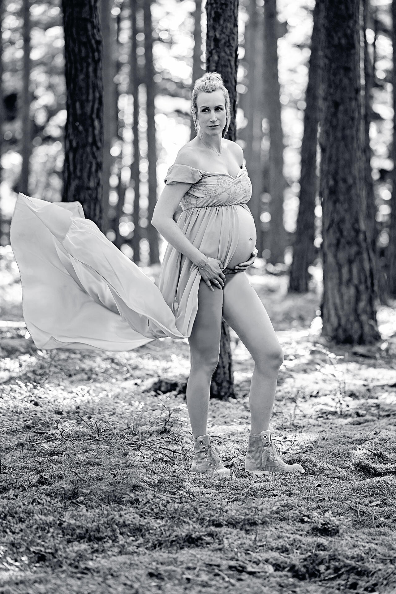 Schwangere Frau in wallendem Kleid im Wald