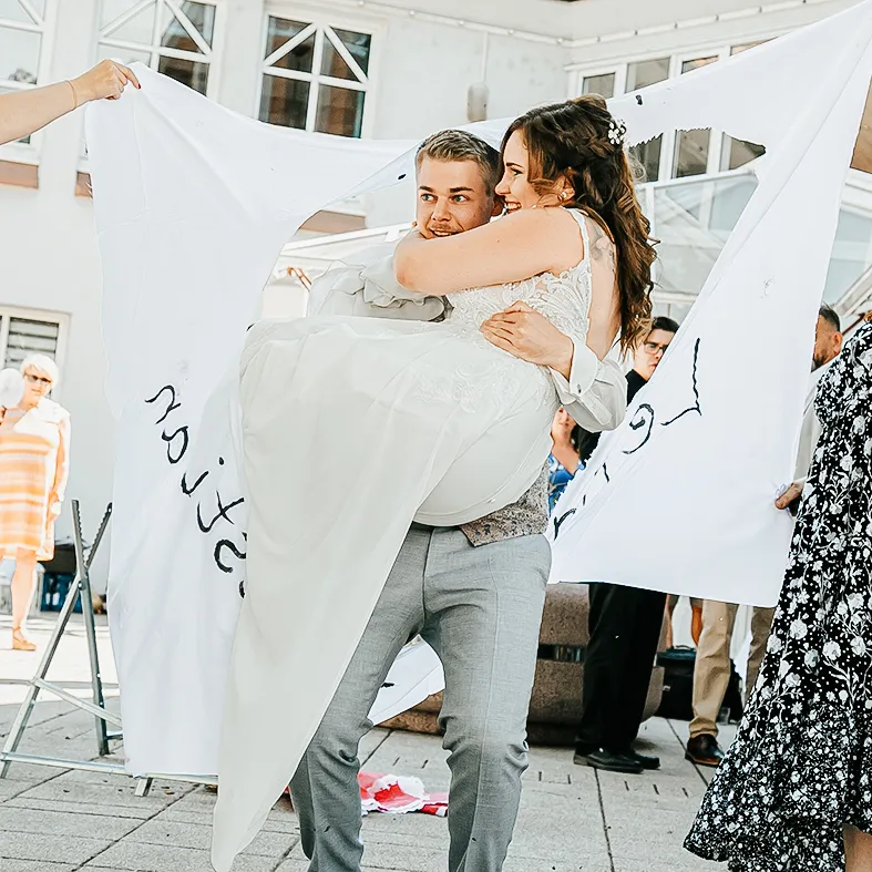 Braut wird von Bräutigam getragen