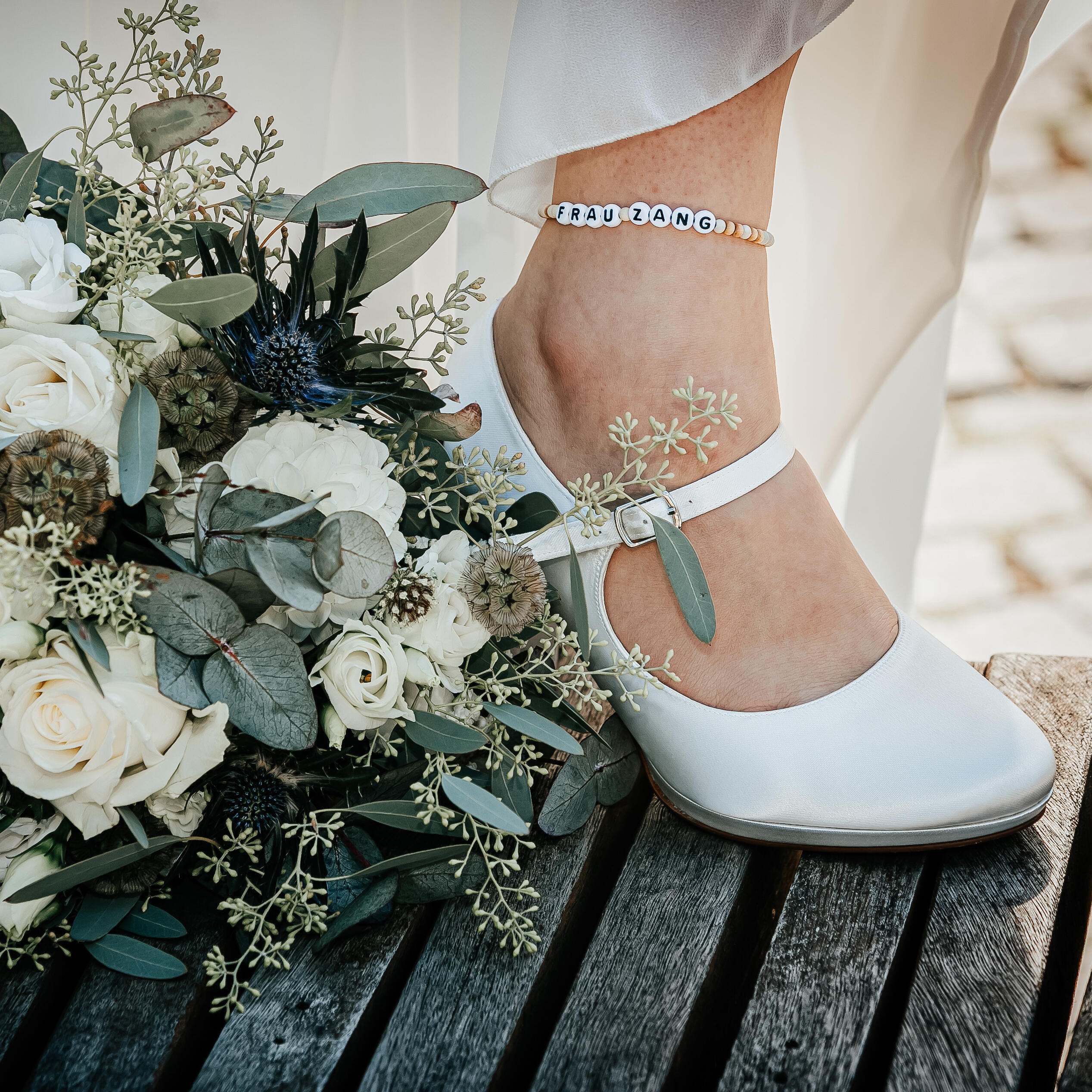 Brautstrauß mit Fuß und Schuh der Braut mit Namensfußkettchen