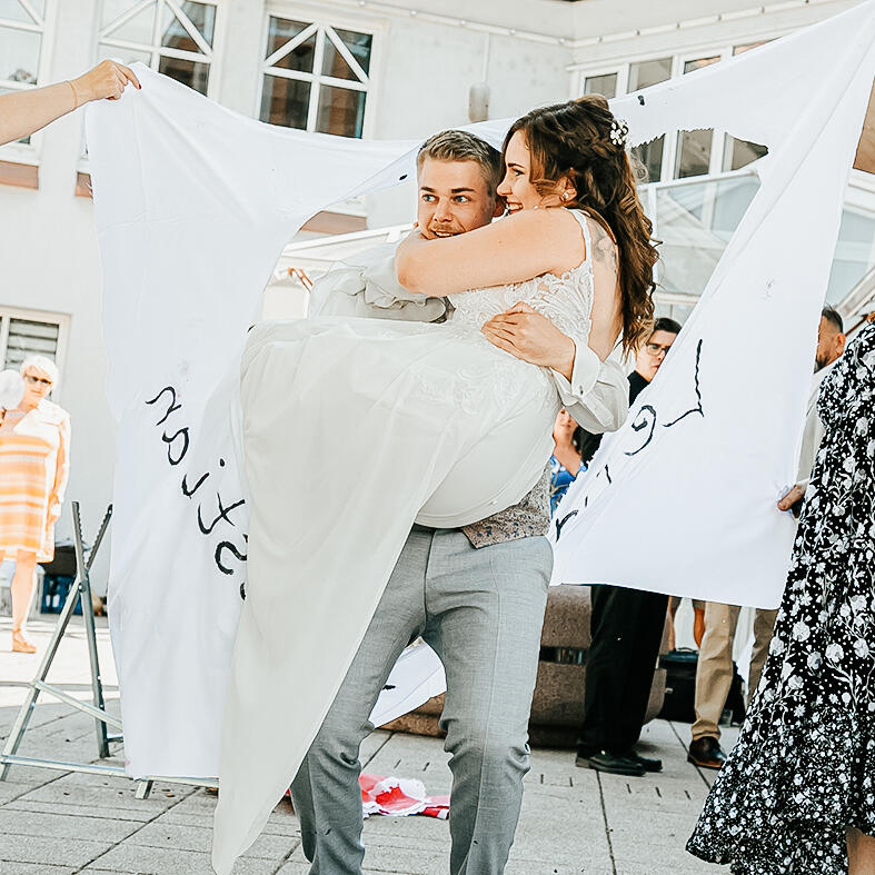 Braut wird von Bräutigam getragen